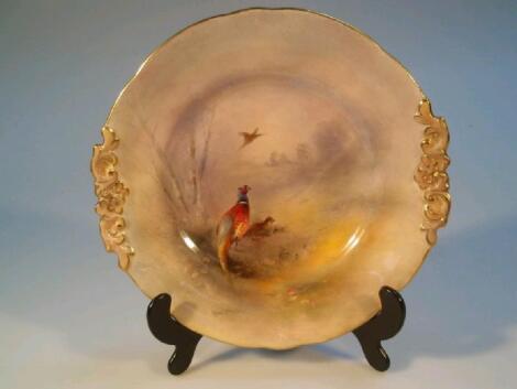 A Royal Worcester plate hand painted with a winter landscape and pheasants