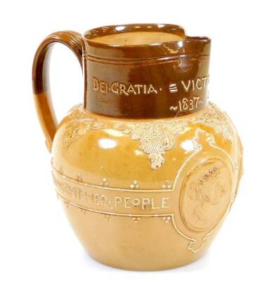 A Royal Doulton Queen Victoria Jubilee stoneware jug, in two colours raised with medallions of the Young and Old profiles, slip decorated with Lasting God She Wrought Her People, with beak spout and strap handle, impressed marks beneath, 17cm high.