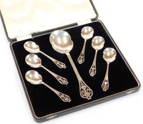 A George V silver spoon set, by Viners, comprising serving spoon 24cm high, and six shaped spoons, each with pierced floral tops and shaped bowls, 9oz. (cased)