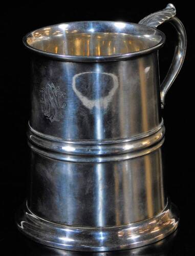 A George V silver mug, with cylindrical body, acanthus capped ear handle, circular foot, London 1918, 14cm high, 15oz.