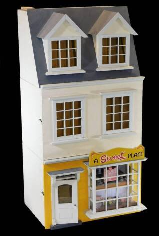 An Anglesey doll's house sweet shop, with articulated front, with shop interior to the lower section, stamped to back, 76cm high, 39cm wide, 37cm deep.