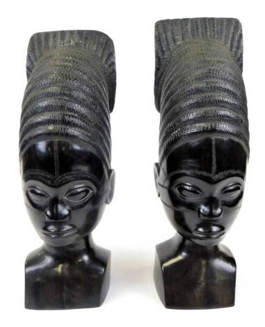 A pair of African tribal heads, with elaborate shaped hair, unmarked, 35cm high.