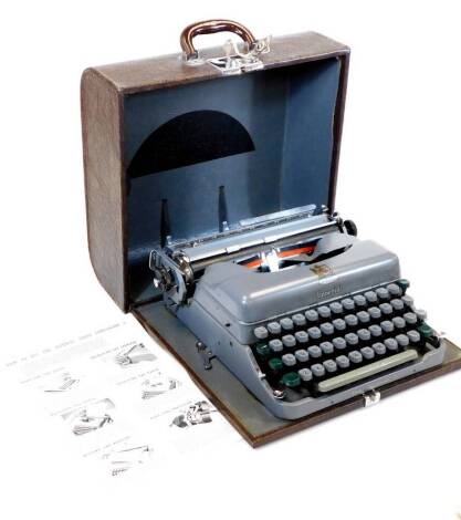 A vintage 20thC Imperial Good Companion No.5 portable typewriter, in grey, with grey and green keys, in a partially stitched case, 36cm wide.