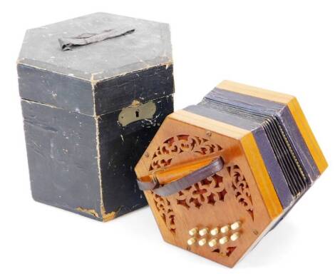 An early to mid 20thC concertina squeeze box, of hexagonal form with ten buttons to either side, partially cased, 19cm wide. (AF)