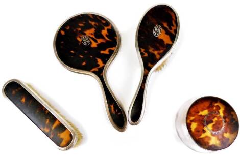 A George V silver and tortoise shell dressing table set, comprising hand mirror 23cm high, clothes brush, hair brush and associated jar and cover, London 1925, etc. (a quantity)