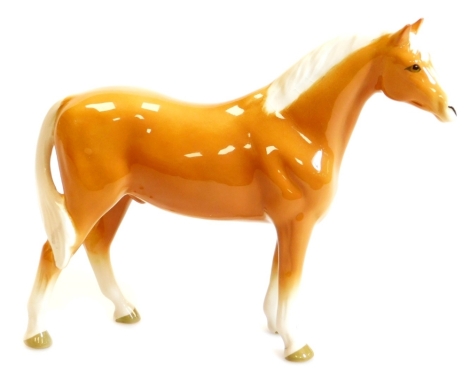 A 20thC Beswick figure of a standing Palomino horse, printed marks beneath, 20cm high.