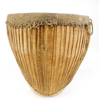 A 20thC African tribal drum, of shaped form, with strung centre on circular foot, 55cm high. - 2