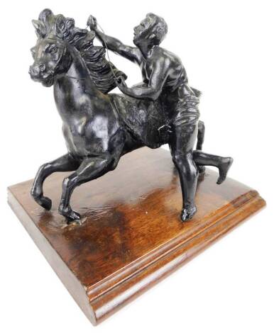 A 20thC cast metal figure of horse and groom, on mahogany base, unmarked, 24cm wide.