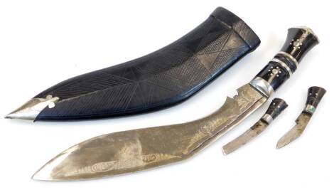 A Kukri with shaped blade, miniature knives and leather scabbard with metal mounts, 41cm wide.