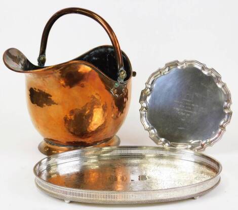 Various metalware, silver plated salver dated 1967 with pie crust edge, 55cm wide, an early 20thC copper coal helmet and a galleried tray of oval form with bright cut centre.