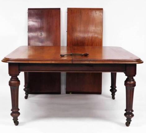 A Victorian mahogany extending wind out dining table, the moulded oblong top raised on heavy reeded legs terminating in castors, when closed 76cm high, 155cm wide, 124cm deep, with two additional leaves, 48cm wide and 52cm wide and winder.