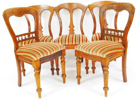 Five very similar Victorian mahogany dining chairs, each with shaped cresting rails, vertical carved back splats and removable seat pads in later Regency striped style material on reeded front and sabre back legs, 92cm high. (5)