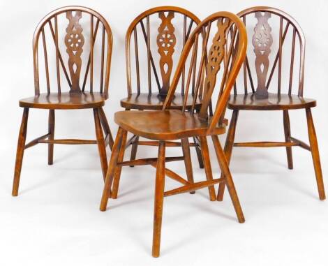 A set of four 20thC oak wheel back dining chairs, with shaped seats on turned legs each joined by a H stretcher, 89cm high. (4)