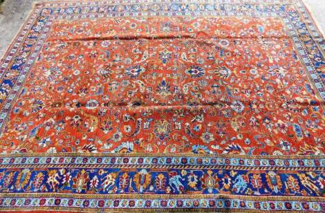 A 20thC Persian carpet, of Tabriz design, the outer field decorated with a repeat floral pattern predominately in blue, red and yellow, the inner section with further flowers, 500cm x 255cm.