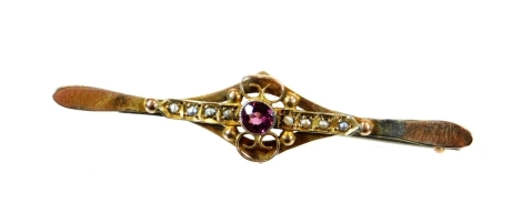 An Edwardian bar brooch, of ellipse form with plain pin back set with an arrangement of small white stones centred by pink stone with a shaped surround, marked 9c, 5cm wide, 1.8g all in.