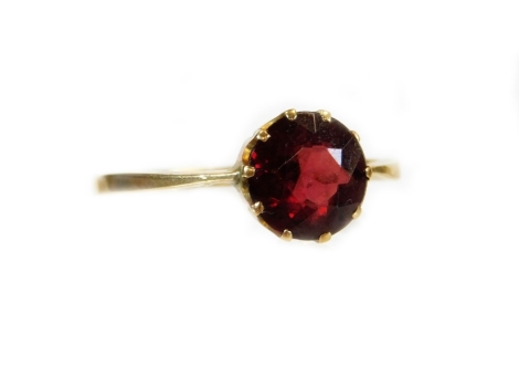 A ladies solitaire dress ring, claw set with a garnet on a plain shank, marked 9ct, size N, 2g all in, in Bell Brothers Doncaster box.