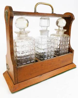 An Edwardian oak tantalus, with three decanters, on a plain base with metal mounts and key, 34cm high. (AF) - 2