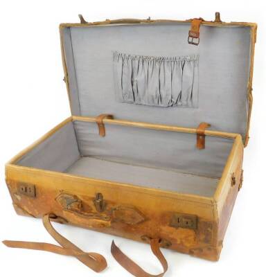 An early 20thC tan leather travel case, of rectangular form with inner pouch and plain interior, the exterior with leather handle and long straps, 23cm high, 72cm wide, 41cm deep. (AF) - 2