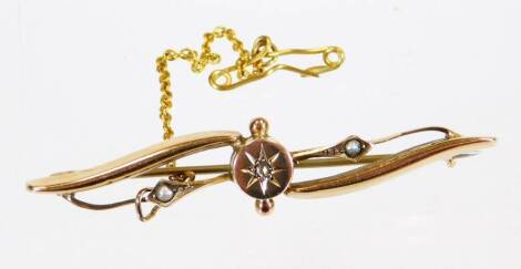 An Edwardian brooch, of entwined form set with small pearls, with star centre and plain pin back, marked 9ct, chain fastener, 5cm wide, 3g all in.