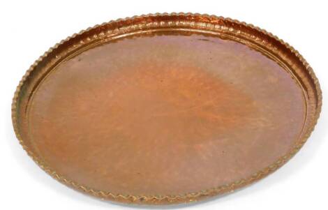 A large 19thC copper charger, with crimped edge, 75cm wide.