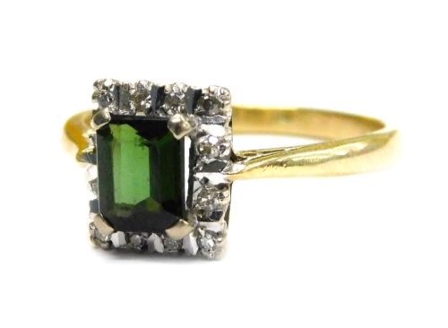 An 18ct gold stone set dress ring, with square dark green stone in four claw setting, surrounded by tiny diamonds in a claw platinum setting, with bar breaks, V splayed shoulders, ring size O, 3.6g all in.