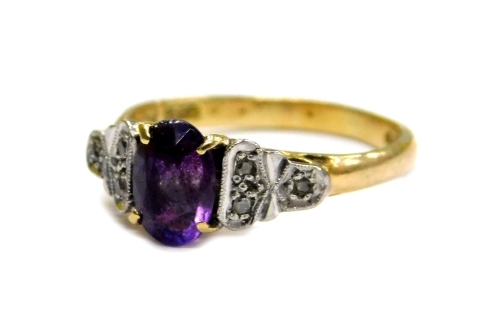 An 18ct gold and platinum amethyst and diamond dress ring, set with oval cut amethyst stone in four claw setting, and Art Deco style platinum sides set with three round brilliant cut diamonds, ring size N, 3.2g all in.