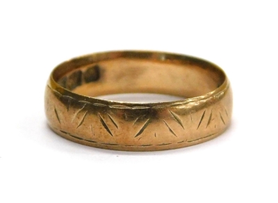 A 9ct gold wedding band, with rubbed etched design, ring size J, 2g all in.