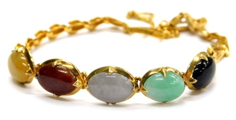 A multi stone set bracelet, set with five oval semi precious stones, in a claw setting, in unmarked gold coloured setting, on a gold plated fan design bracelet, with clasp and safety chain, 17cm long overall.