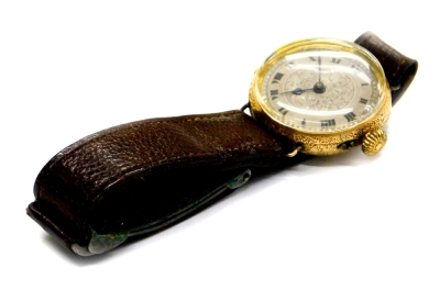 A gentleman's wristwatch, with circular watch head, on silvered floral scroll dial with Roman numerals, in a heavily engraved floral motif casing, marked 14kt, numbered 31623, on a brown leather strap, the dial 3cm diameter.