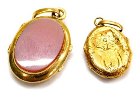 Two small oval lockets, comprising a memorial oval locket, with clear panel to centre, with floral scroll and bow decoration, in yellow metal, unmarked, together with an agate set double sided locket, with pale oval agate, in a gold coloured setting, unma