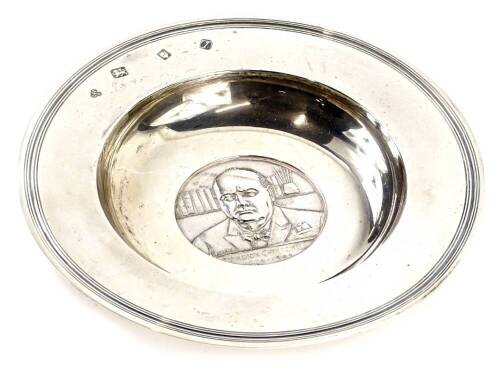 A commemorative silver Armada dish, cast centrally with a medallion of Winston Churchill, dated 1874 to 1965, the reverse bearing the slogan "Very Well Alone", London 1966, 8¼oz, 17cm diameter. Provenance: The Estate of Miss Rachel Monson.