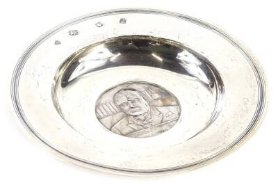 A commemorative silver Armada dish, cast centrally with a medallion of Winston Churchill, dated 1874 to 1965, the reverse bearing the slogan "Very Well Alone", London 1966, 8¼oz, 17cm diameter. Provenance: The Estate of Miss Rachel Monson.