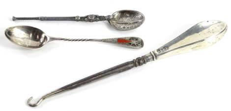 An Edwardian silver Arts and Crafts type teaspoon, the handle inset with agate in the Celtic manner maker stamp J.F., a plated silver Celtic revival anointing type spoon and button hook with a silver handle (3).