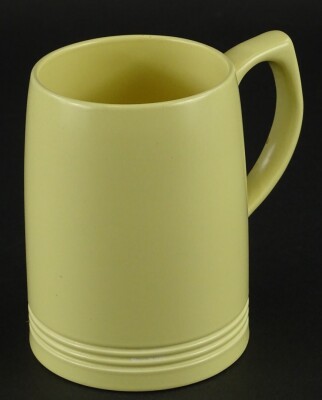 A Keith Murray Wedgwood yellow glazed mug, printed marks to underside, 12cm high.