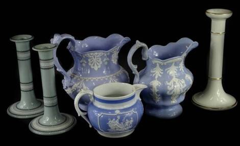 A collection of 19thC ceramics, to include two similar relief moulded jugs with a purple glaze, one with raised stamp, a pair of candlesticks, another purple glazed jug and a single candlestick (6).