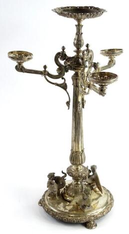 A Victorian silver plated centrepiece, with four arms, the reeded column applied with scrolls, mask, etc., on a circular base applied with similar motifs, with a floral border and lobed bun feet, lacking glass dishes, 54cm high.