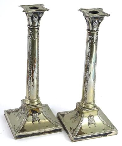 A pair of late 19thC silver plated neo classical candlesticks, each decorated with swags, patera, bows, etc., 31cm high.