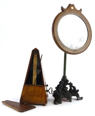 A late Victorian ebonised spelter and brass shaving stand, with circular inlaid wooden mirror, etched column and rococo scroll cast base, 39cm high and a metronome in a walnut case (2).