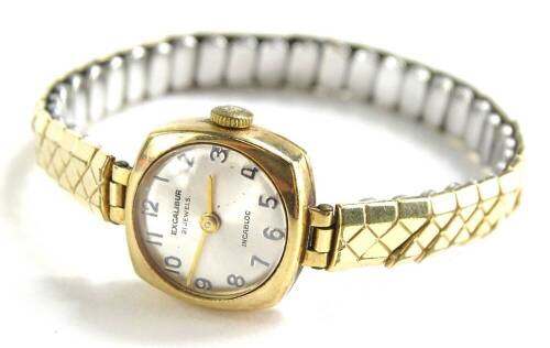 An Excalibur Incabloc ladies wristwatch, with small square set dial, and silvered backing, with twenty one jewel movement, yellow metal, unmarked, on expanding 9ct gold bracelet, 15.1g all in.