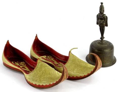 A pair of Eastern leather shoes or slippers, each elaborately decorated in gilt and an Indian bell (3).