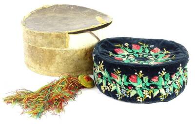 An unusual Victorian embroidered velvet cap, decorated with flowers, leaves, etc., with a gold, red and green tassel, original box, indistinct name of Matthews to the lid and bearing date 1883.