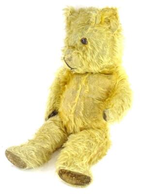 A vintage teddy bear, with velvet pads (AF), label to reverse stating Made in England, 53cm long