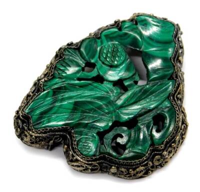 A malachite brooch, of carved design with filigree design bordering, and single row back, marked silver, 5cm wide.