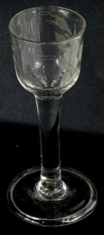 An 18thC wine glass, with wheel cut engraving of flowers and leaves, plain tapering stem and fold over foot, 14cm high.