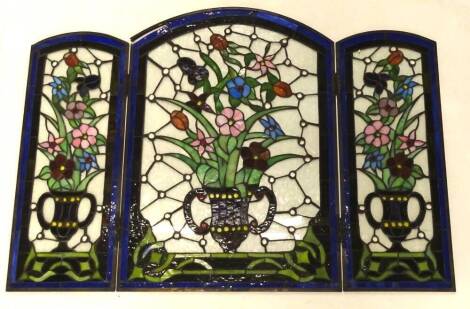 An unusual stained glass and leaded small table screen, decorated with vases of flowers etc., 72cm x 52cm enclosed.