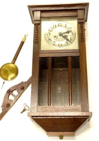 A 1920's oak wall clock, the silver dial with Arabic numerals, 81cm high.