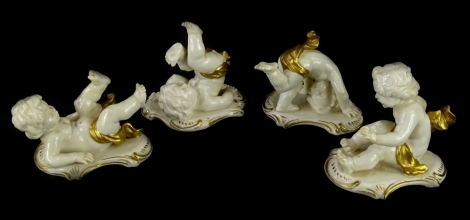 A set of four continental porcelain piano type putti, each picked out in gilt, printed marks to underside, possibly German.