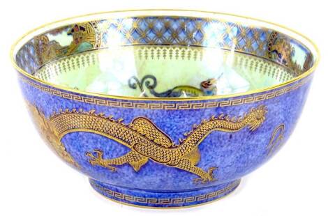 A Wedgwood Dragon lustre bowl, decorated with dragons to the centre on pearlescent ground with gilt borders, the exterior with a mottle blue glaze, printed marks in gilt to underside and pattern no. Z4829, 21cm diameter.