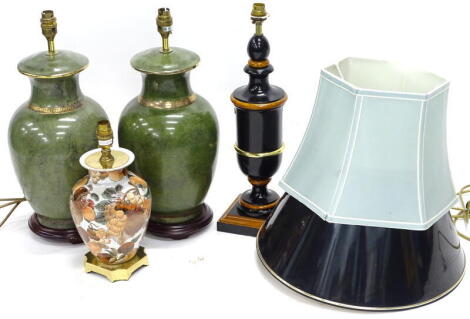 A pair of ceramic green based lamp bases, a composite ebonised and simulated wood lamp base, and oriental lamp base, decorated with fruit and two shades.