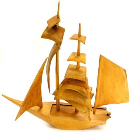 A carved Eastern teak model of a two masted sailing boat, with sliding cover, 65cm high.